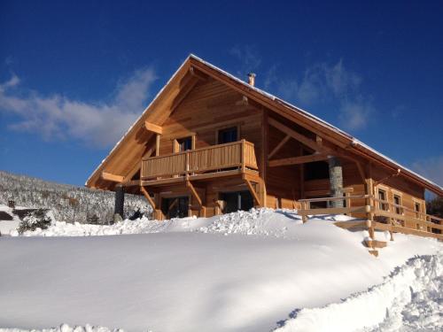 a log cabin in the snow with snow at Au cœur du bois in Le Bouilly