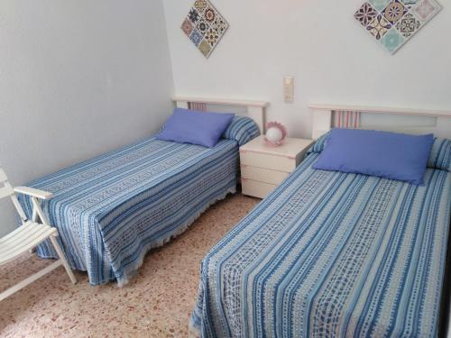 Playa de GandiaにあるApartamento Parque playaのベッドルーム1室(隣り合わせのベッド2台付)