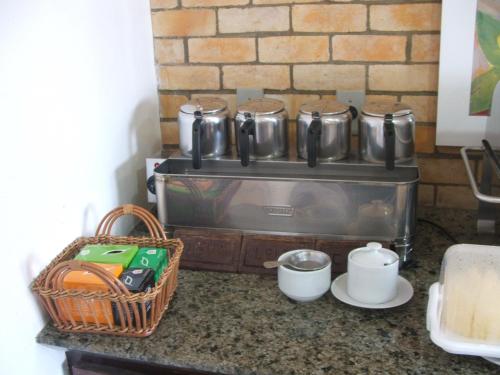 a kitchen counter with a stove with pots and pans at Pousada da Ladeira in Pipa