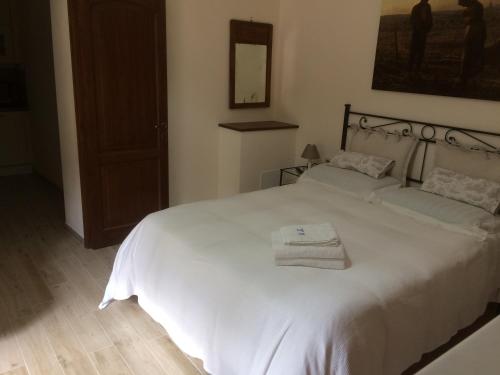 a bedroom with a white bed with towels on it at Agriturismo Terrarossa in Pistoia