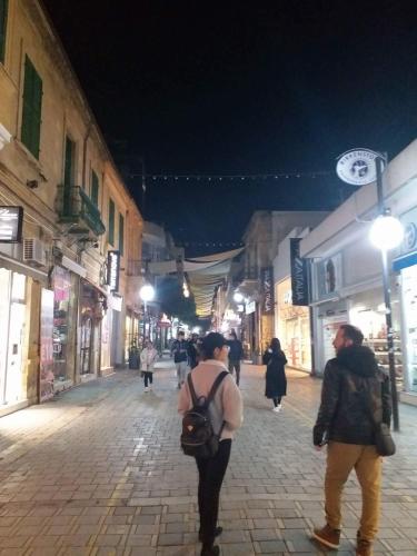 a group of people walking down a street at night at Marina's Rooms in Larnaka