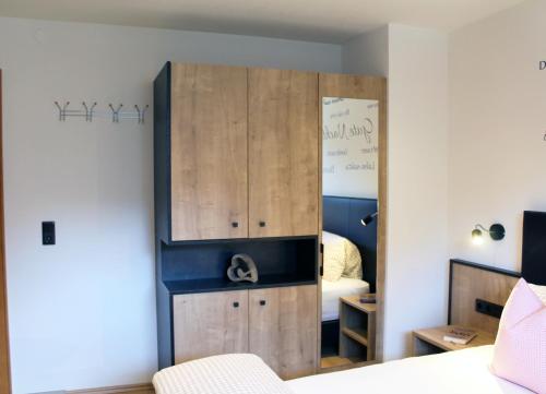 1 dormitorio con un gran armario de madera junto a una cama en Apart Riffla, en Kappl