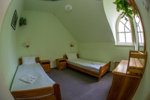 a attic room with two beds and a window at Aqua Line Apartmanház in Hajdúszoboszló