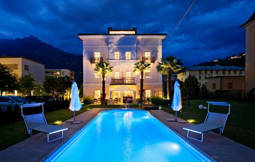 ein Haus mit einem Pool vor einem Haus in der Unterkunft Garni Villa Tyrol - Adults Only in Meran