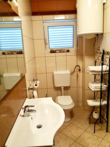 a bathroom with a white sink and a toilet at Villa Skoric in Orebić