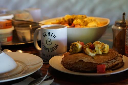 a table with a plate of food and a cup of coffee at Buena Vista Surf Club in Playa Maderas