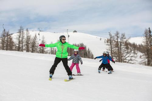 a group of people on skis in the snow at Ferienwohnungen Hotel Garni Dörflerwirt in Aflenz Kurort