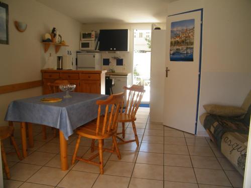 une cuisine et une salle à manger avec une table et des chaises dans l'établissement Villa T3, 4 personnes, Le Clos du Soleil, à Narbonne-Plage