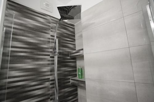 a shower with a glass door in a bathroom at George Studio in Athens