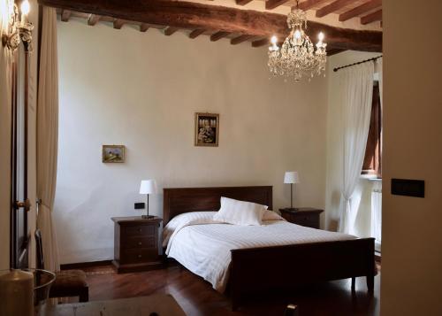 a bedroom with a bed and a chandelier at Residenza Le Logge in Gubbio