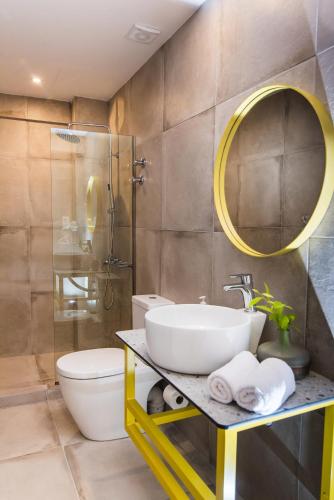 a bathroom with a sink and a toilet and a mirror at Natali Apartments by Estia in Malia