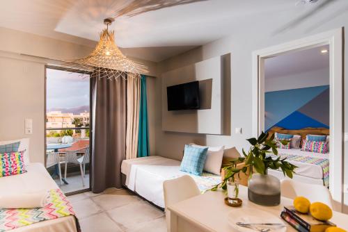 マリアにあるNatali Apartmentsのベッドとリビングルームが備わるホテルルームです。
