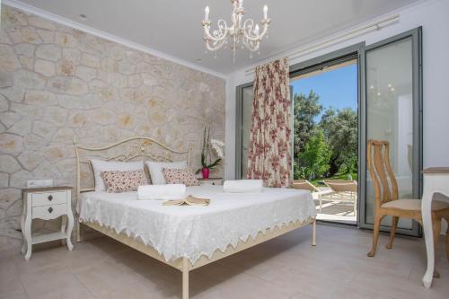a bedroom with a bed and a large window at Alexandros Stone House in Nydri