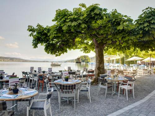 a group of tables and chairs next to a lake at Hotel-Restaurant-Schifflände in Birrwil