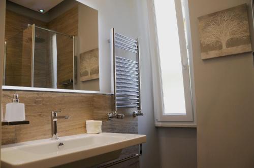baño con lavabo, espejo y ventana en Nomentana House, en Roma