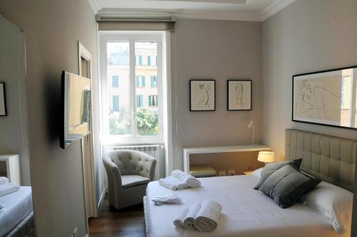 a bedroom with a bed and a chair and a window at Nomentana House in Rome