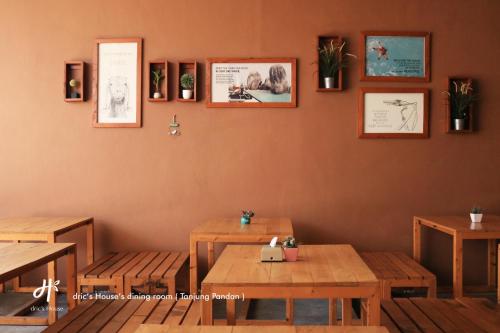 a restaurant with wooden tables and pictures on the wall at dric's House in Tanjungpandan