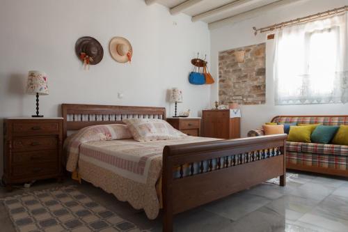 a bedroom with a bed and a couch in it at Ergina Summer Resort in Antiparos