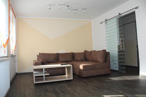 sala de estar con sofá marrón y mesa en FEWO Loos, en Ehrenfriedersdorf