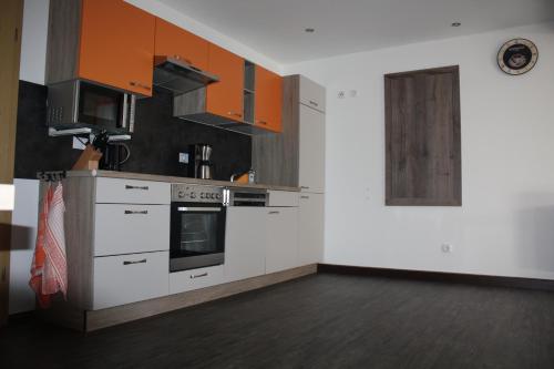 una cocina con electrodomésticos de color naranja y blanco en una habitación en FEWO Loos, en Ehrenfriedersdorf