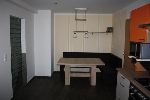 uma pequena cozinha com uma mesa de madeira num quarto em FEWO Loos em Ehrenfriedersdorf