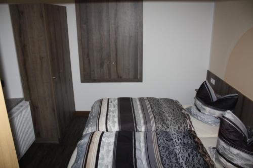 um quarto com uma cama com um edredão listrado em FEWO Loos em Ehrenfriedersdorf