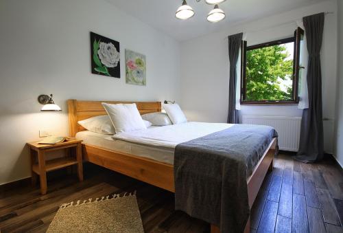 a bedroom with a large bed and a window at Lagom Apartments in Drežnik Grad