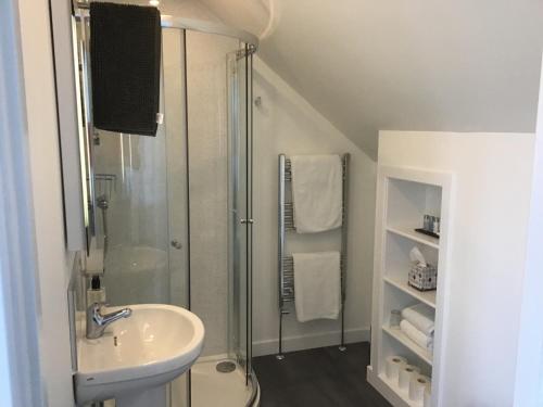 a white bathroom with a shower and a sink at Gramarvin B&B in Oban