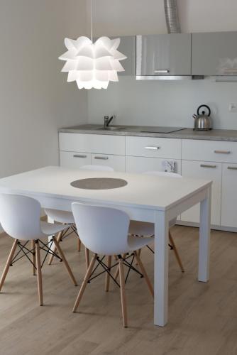 a kitchen with a white table and two white chairs at Apartmán SUN Dolní Morava in Dolní Morava