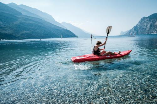 a man on a red kayak in the water at Hotel Villa Alberta in Nago-Torbole