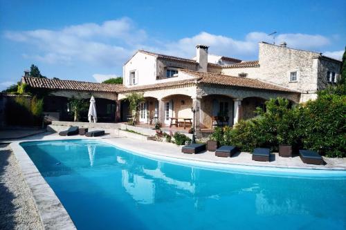 uma casa com piscina em frente a uma casa em Residence Le Saint Victor em Fontvieille