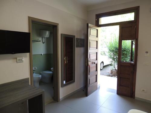 a bathroom with a toilet and a door with a window at Camping Zeus in Pompei