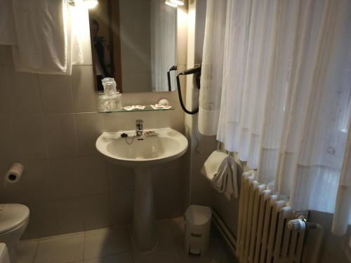 a white bathroom with a sink and a toilet at Hotel Xabier in Javier