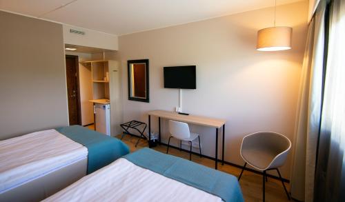 a hotel room with two beds and a desk at Hotel Kivitasku in Kaarina