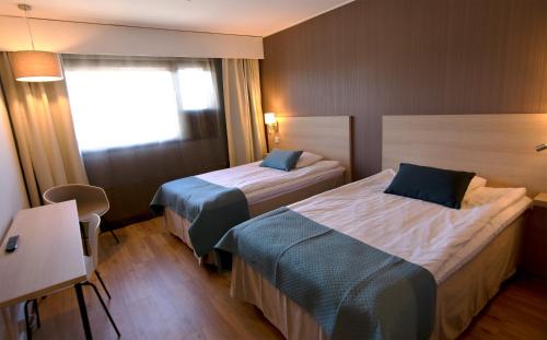 a hotel room with two beds and a window at Hotel Kivitasku in Kaarina