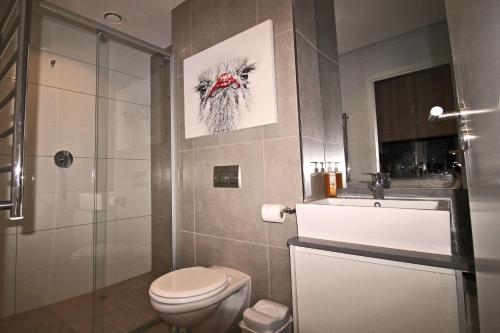 a bathroom with a toilet and a glass shower at Sensational Sentinel in Cape Town