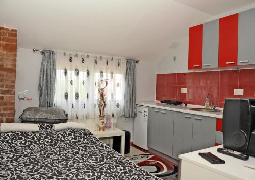 a small room with a bed and a kitchen at House La Strada in Negotino