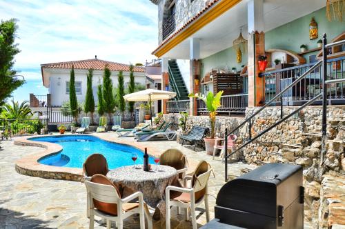 a patio with a table and chairs next to a pool at Apartamentos Alma y Montaña in Cómpeta