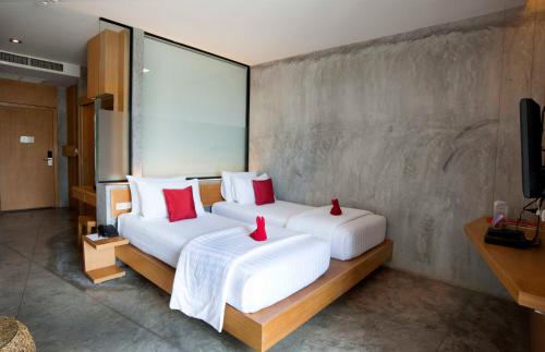a bedroom with two beds with red pillows at The Now Hotel - SHA Extra Plus in Jomtien Beach