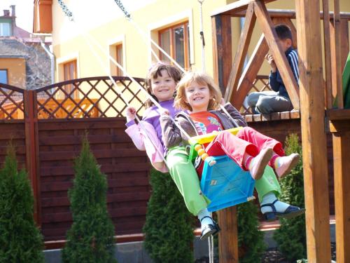 two young children sitting on a swing at Privat Mrzkan in Liptovský Mikuláš