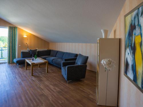 a living room with a blue couch and a table at An der Pappelwende in Ostseebad Karlshagen