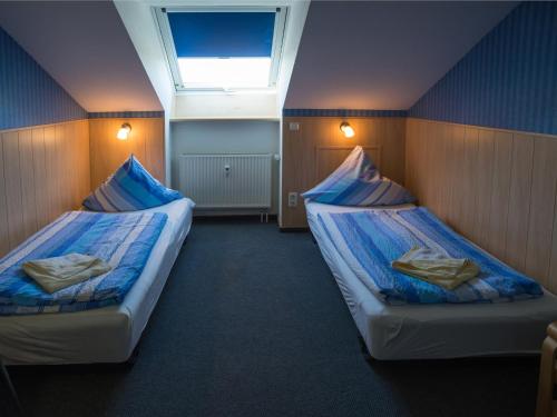 two beds in a small room with a skylight at An der Pappelwende in Ostseebad Karlshagen