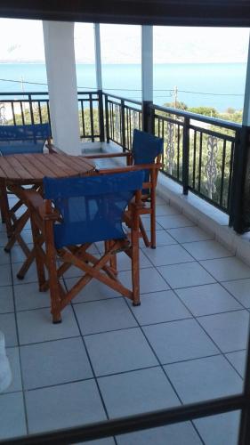 a table and chairs on a balcony with a view of the ocean at The Captain in Elafonisos