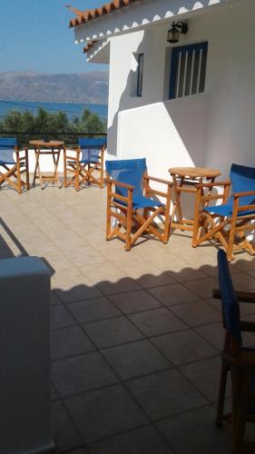 a group of wooden tables and chairs on a patio at The Captain in Elafonisos