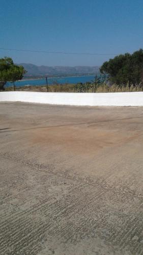 an empty parking lot with the ocean in the background at The Captain in Elafonisos