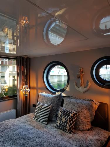 a bedroom with circular windows and a bed with pillows at Riverloft I in Cuxhaven