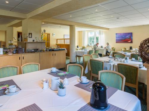 a restaurant with tables and chairs and people in the background at An der Pappelwende in Ostseebad Karlshagen