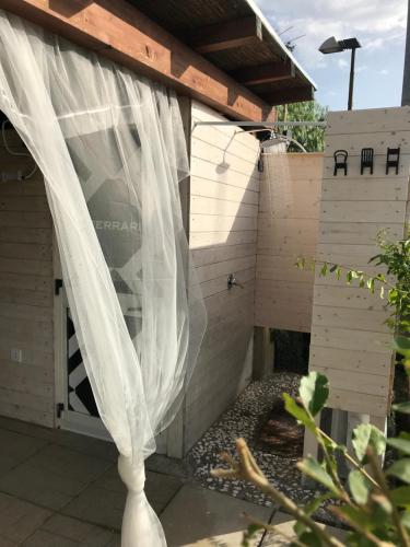 a bird house with a white curtain in a garden at B&B Villa degli Angeli in Bernalda