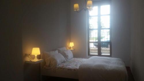 a bedroom with a bed with two lamps and a window at Malvarrosa Calle Pavia in Valencia
