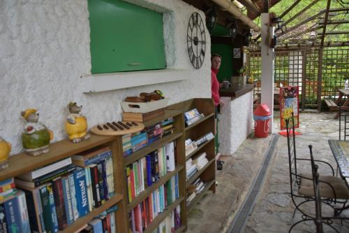 un homme debout à côté d'une étagère remplie de livres dans l'établissement Camping des Drouilhèdes, à Peyremale